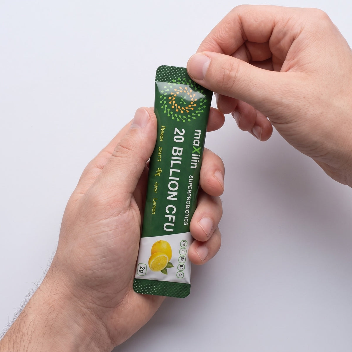 Едно саше MaXilin от 2 g с вкус лимон в ръце